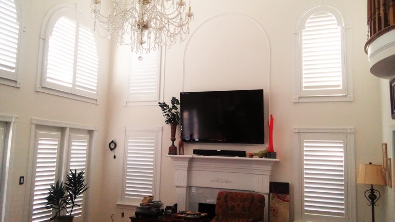 Raleigh great room with wall-mounted TV and arched windows.